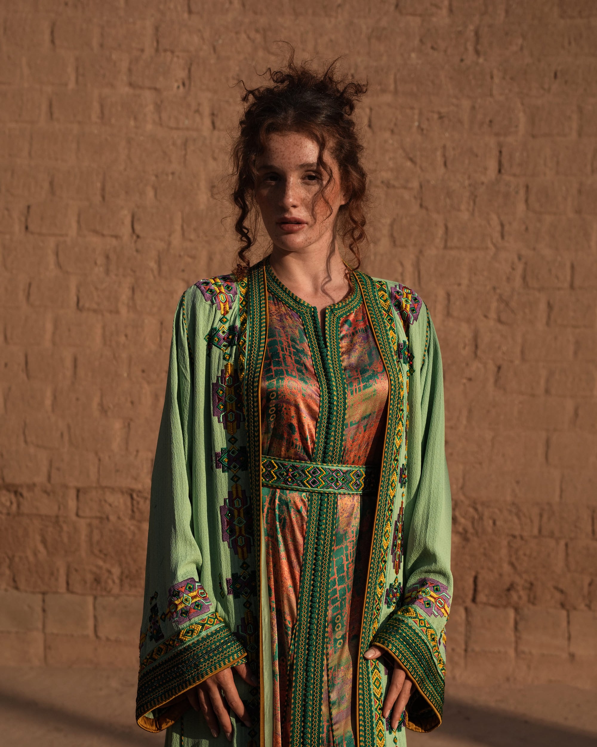 Anise Pavilion anise green Moroccan kaftan with Berber braid trims over a printed dress