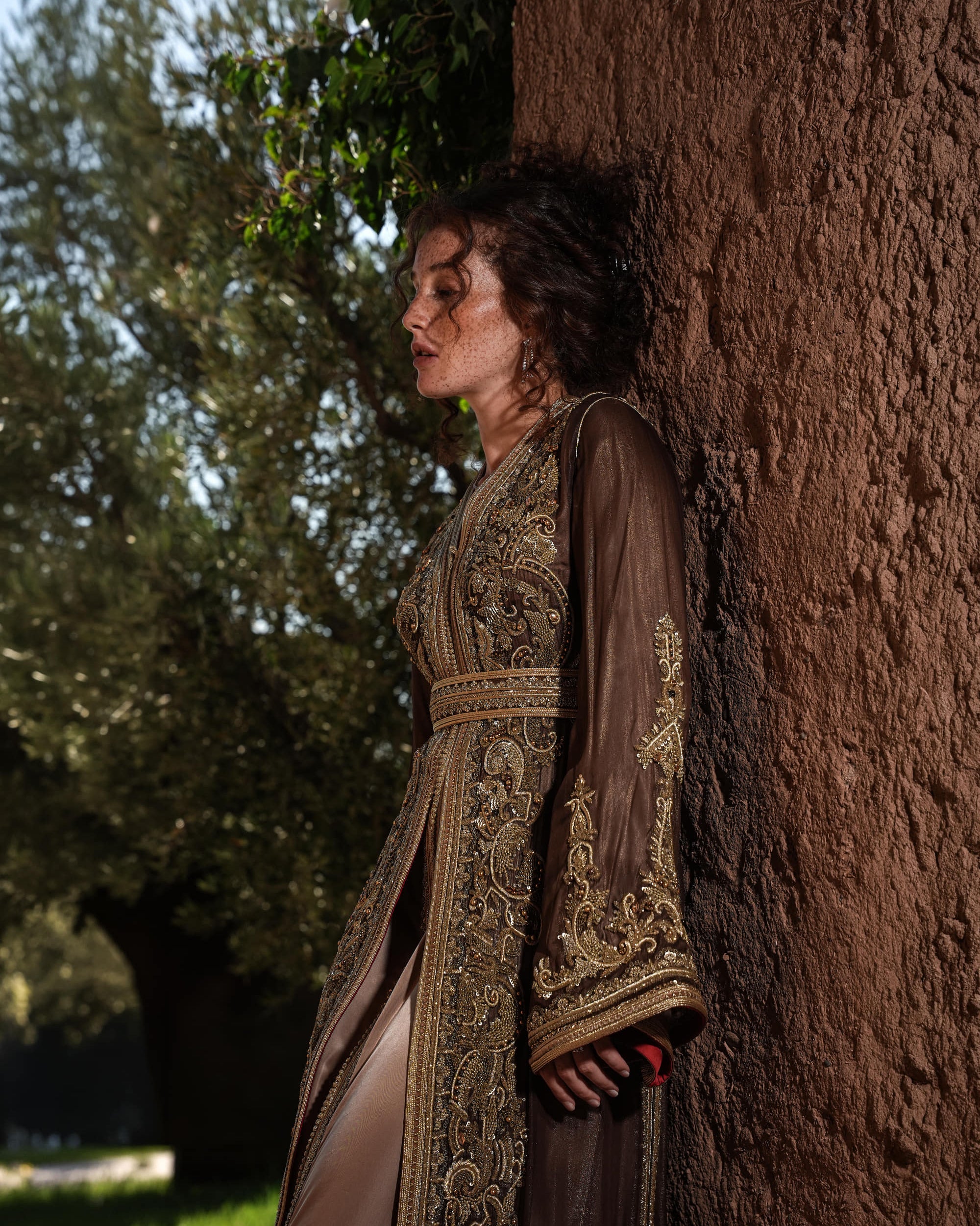 Bronze Reverie lamé organza Moroccan kaftan with gold embroidery, worn open over a champagne dress