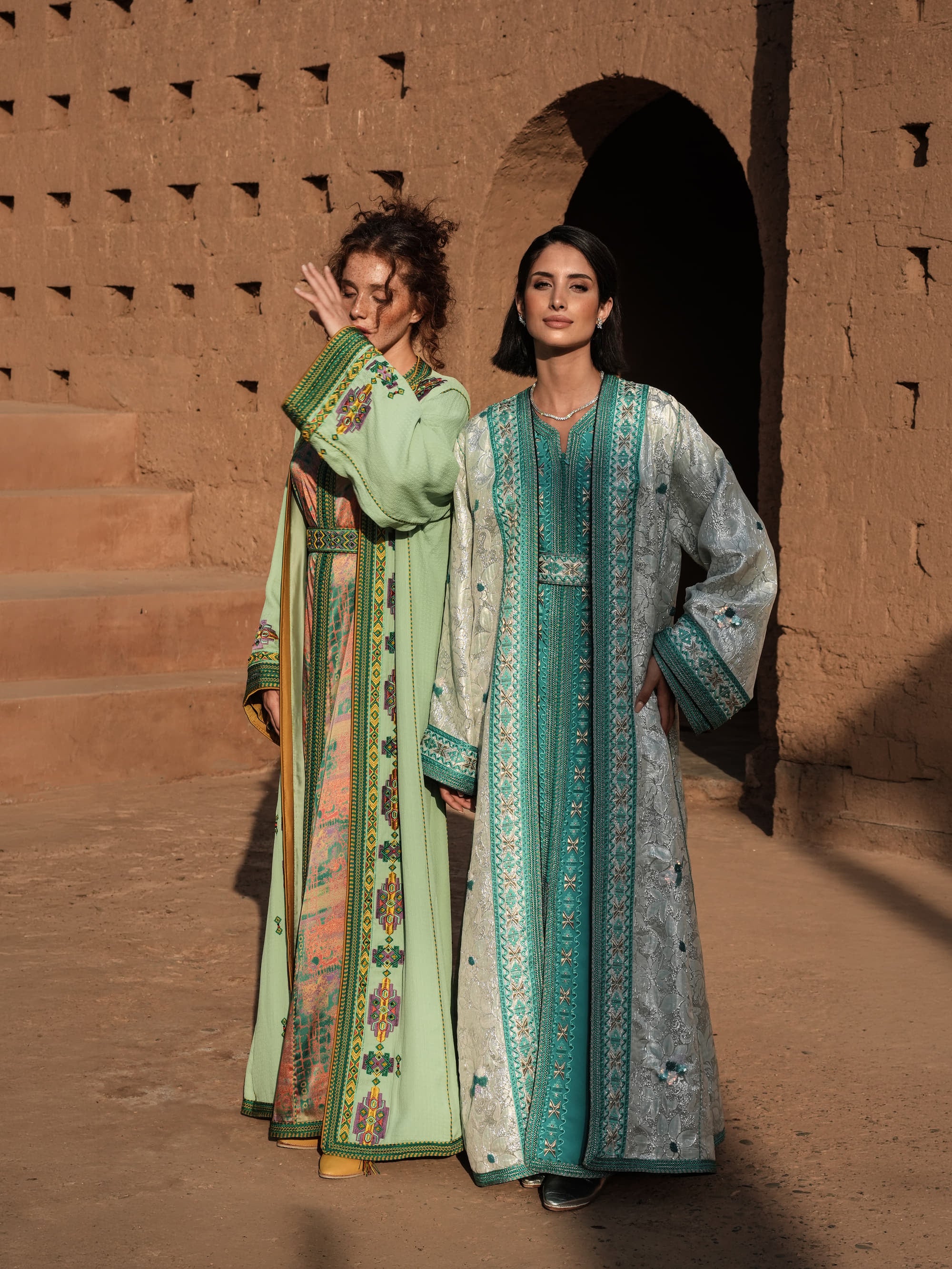 Anise Pavilion anise green Moroccan kaftan with Berber braid trims over a printed dress, shown alongside a second look
